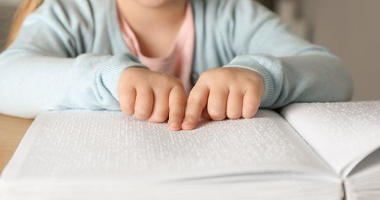 a child reading a book in braille